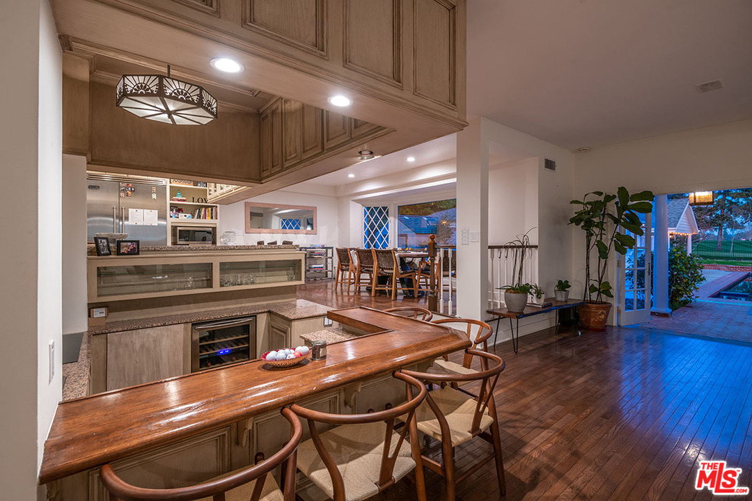20 Toluca Estates Drive Toluca Lake, CA 91602 - Photo 17 of 46 a kitchen with stainless steel appliances kitchen island granite countertop a table chairs and a refrigerator