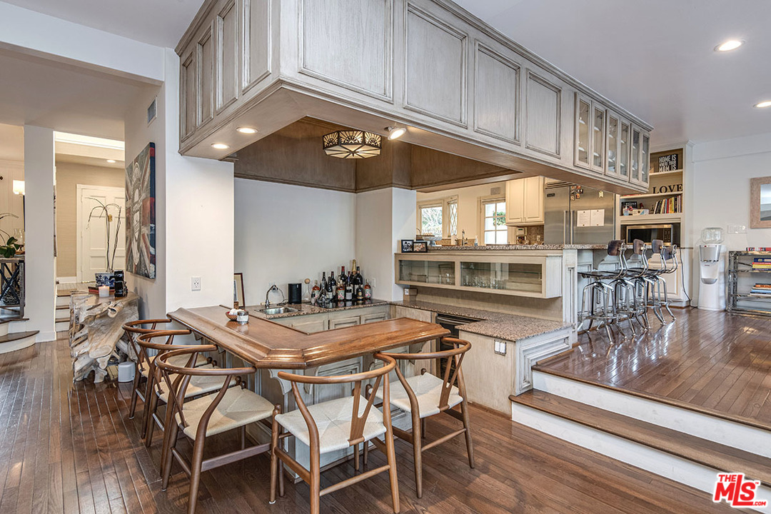 20 Toluca Estates Drive Toluca Lake, CA 91602 - Photo 18 of 46 a kitchen with stainless steel appliances kitchen island granite countertop a table chairs and a stove