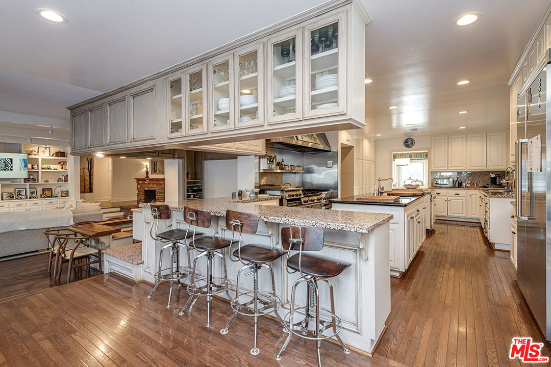 20 Toluca Estates Drive Toluca Lake, CA 91602 - Photo 20 of 46 a kitchen with stainless steel appliances granite countertop a stove top oven a sink a dining table and chairs with wooden floor