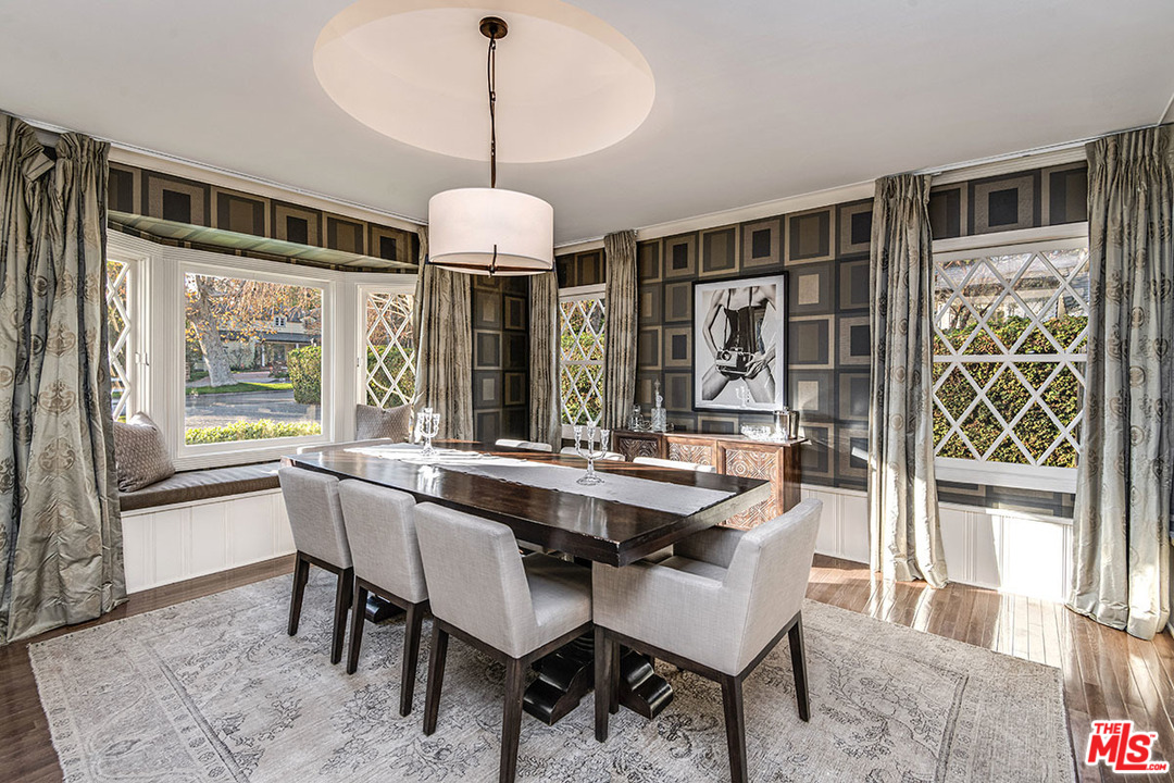 20 Toluca Estates Drive Toluca Lake, CA 91602 - Photo 27 of 46 a dining room with wooden floor a chandelier a wooden table and chairs