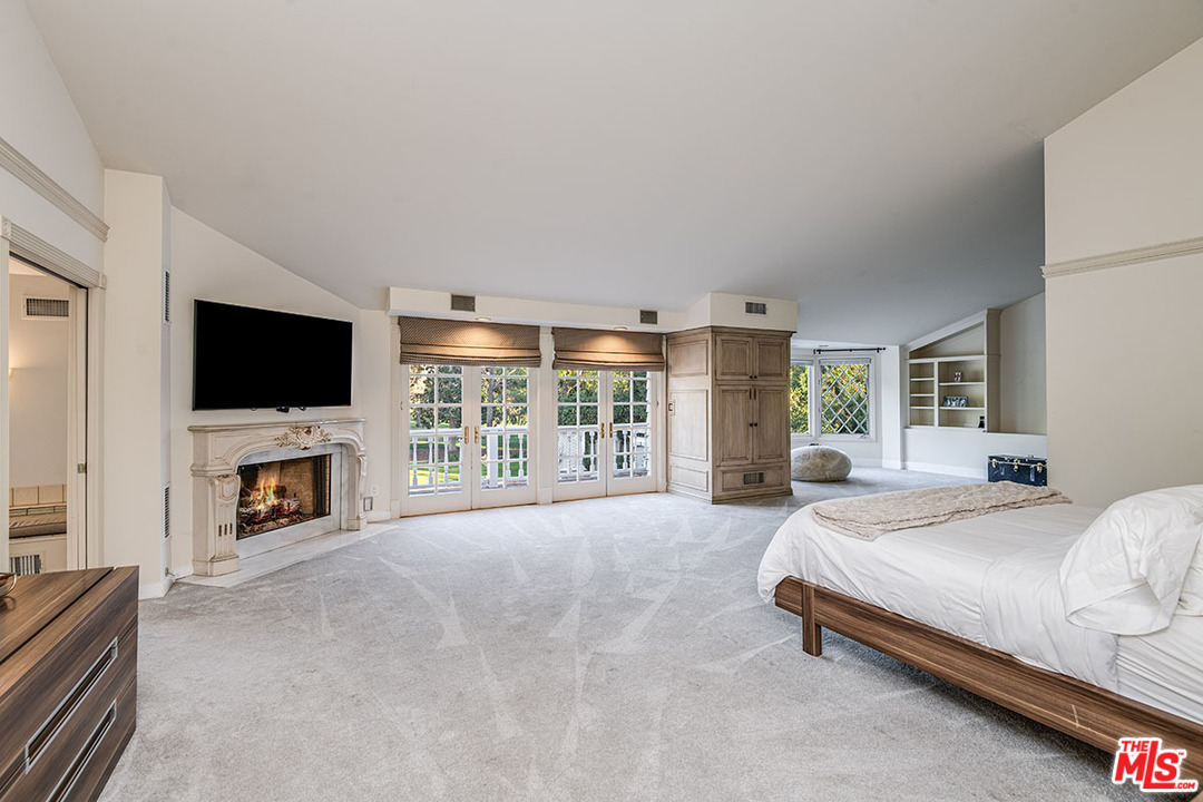 20 Toluca Estates Drive Toluca Lake, CA 91602 - Photo 29 of 46 a spacious bedroom with a large bed and a flat screen tv