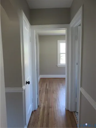 a view of a hallway with wooden floor and closet
