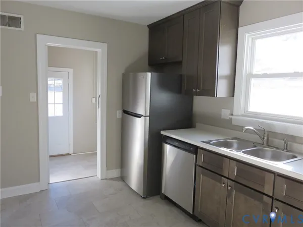 a kitchen with stainless steel appliances granite countertop a refrigerator and a sink