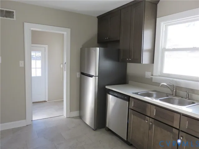 a kitchen with stainless steel appliances granite countertop a refrigerator and a sink