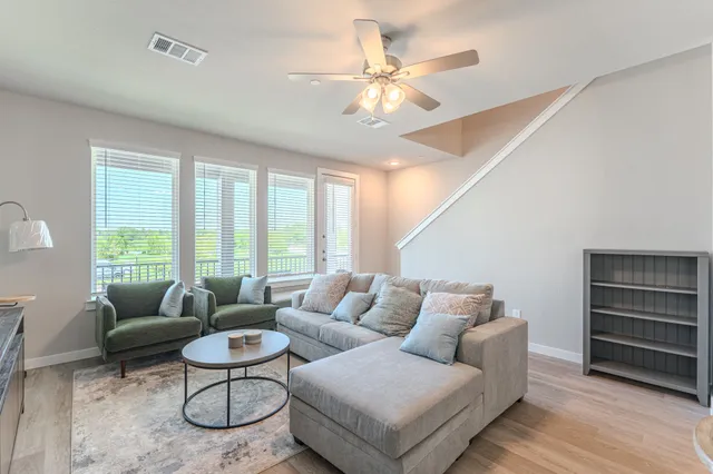 a living room with furniture and wooden floor
