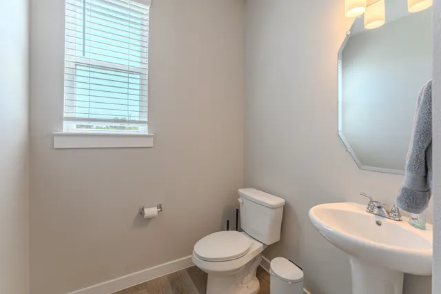 a bathroom with a toilet a sink and a mirror