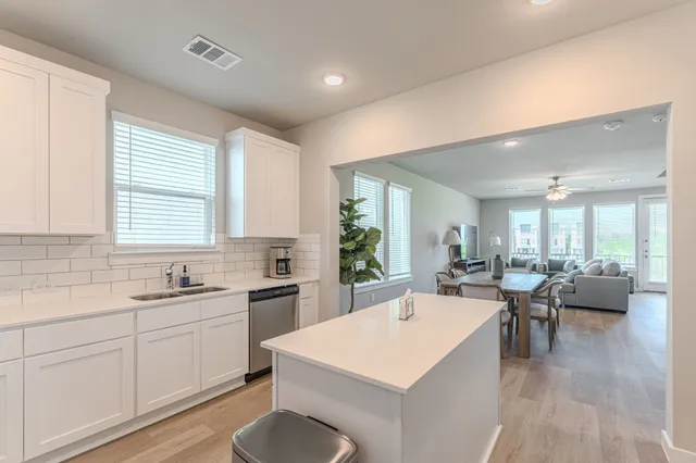 a large kitchen with kitchen island a sink table and chairs