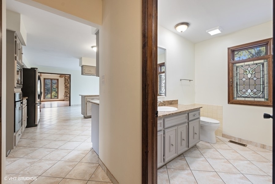6318 Martin Drive Willowbrook, IL 60527 - Photo 14 of 33 a spacious bathroom with a toilet a sink and mirror