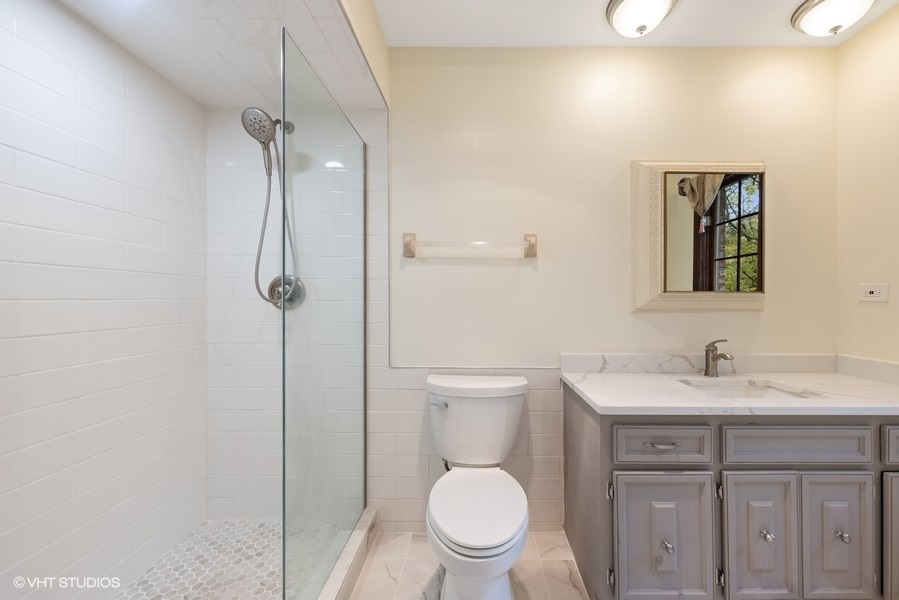 6318 Martin Drive Willowbrook, IL 60527 - Photo 17 of 33 a bathroom with a toilet sink vanity and mirror
