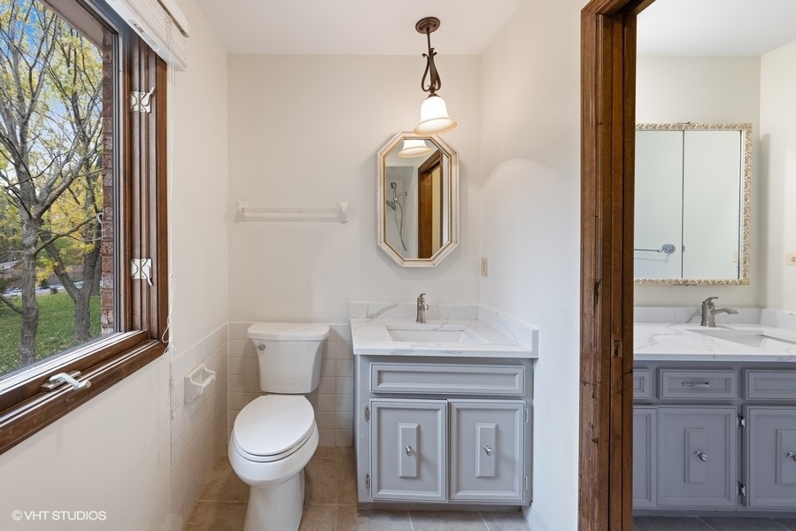 6318 Martin Drive Willowbrook, IL 60527 - Photo 30 of 33 a bathroom with a toilet sink and mirror