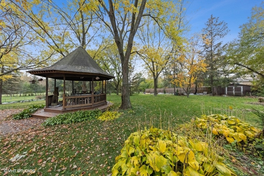 6318 Martin Drive Willowbrook, IL 60527 - Photo 3 of 33 a view of a chair and table under an umbrella in front of house
