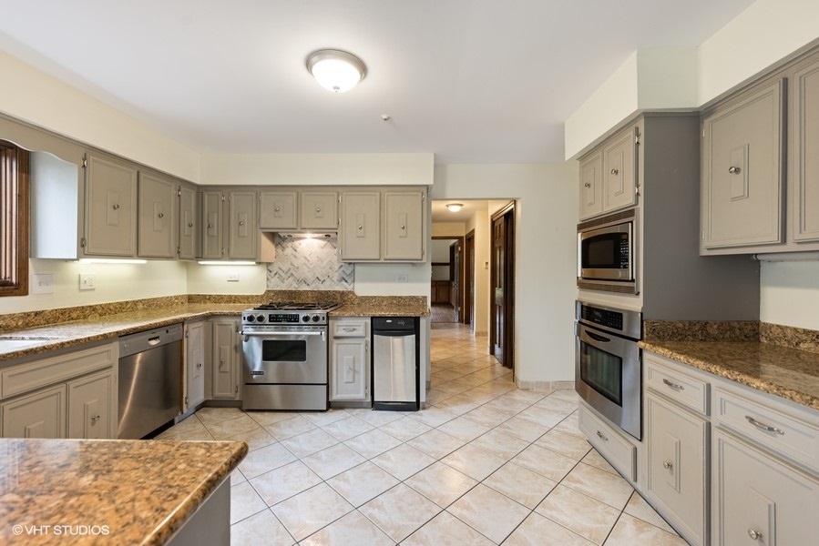 6318 Martin Drive Willowbrook, IL 60527 - Photo 7 of 33 a kitchen with stainless steel appliances granite countertop a stove top oven a refrigerator and a sink