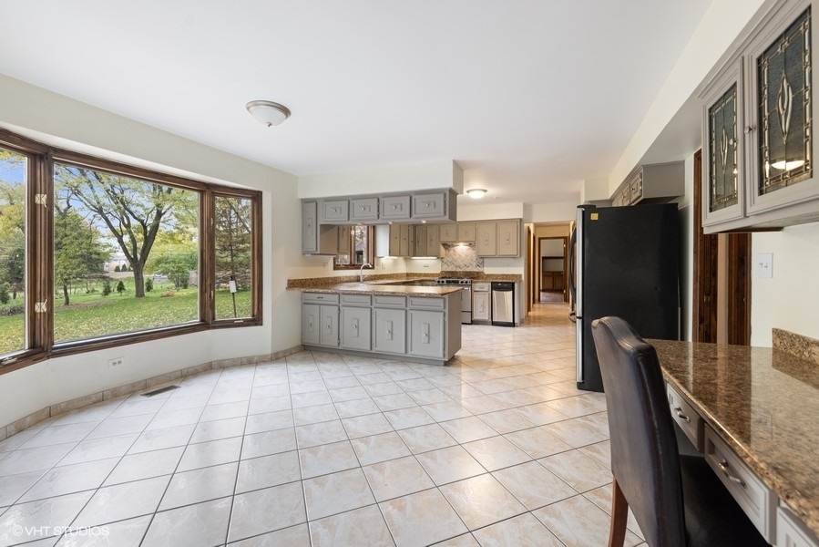 6318 Martin Drive Willowbrook, IL 60527 - Photo 9 of 33 a kitchen with stainless steel appliances granite countertop a refrigerator and a stove top oven