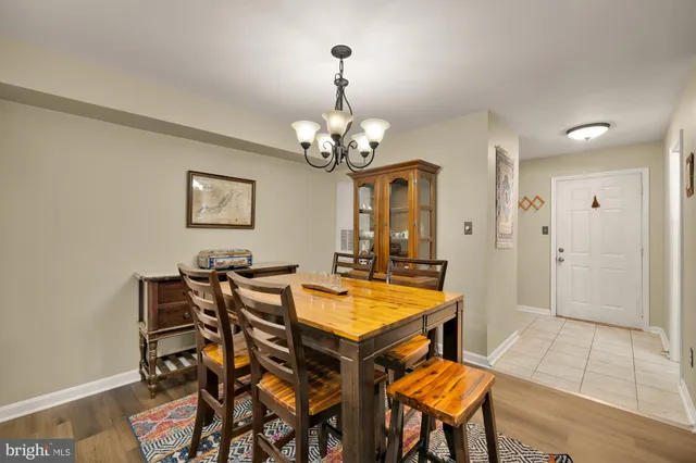 a dining room with wooden floor and chandelier