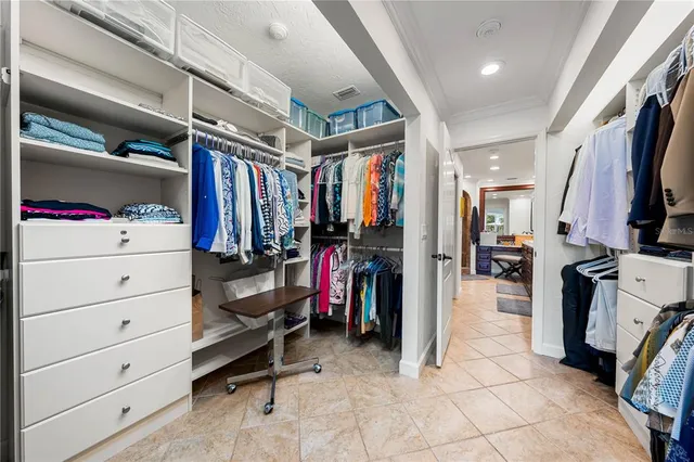 a view of walk in closet with clothes and shoes