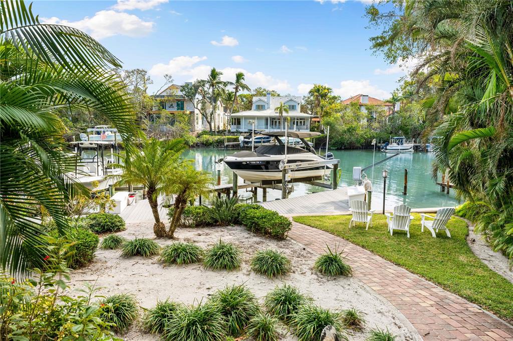 866 Hudson Avenue, Unit 866 Sarasota, FL 34236 - Photo 4 of 38 a view of a lake with a bench in front of house
