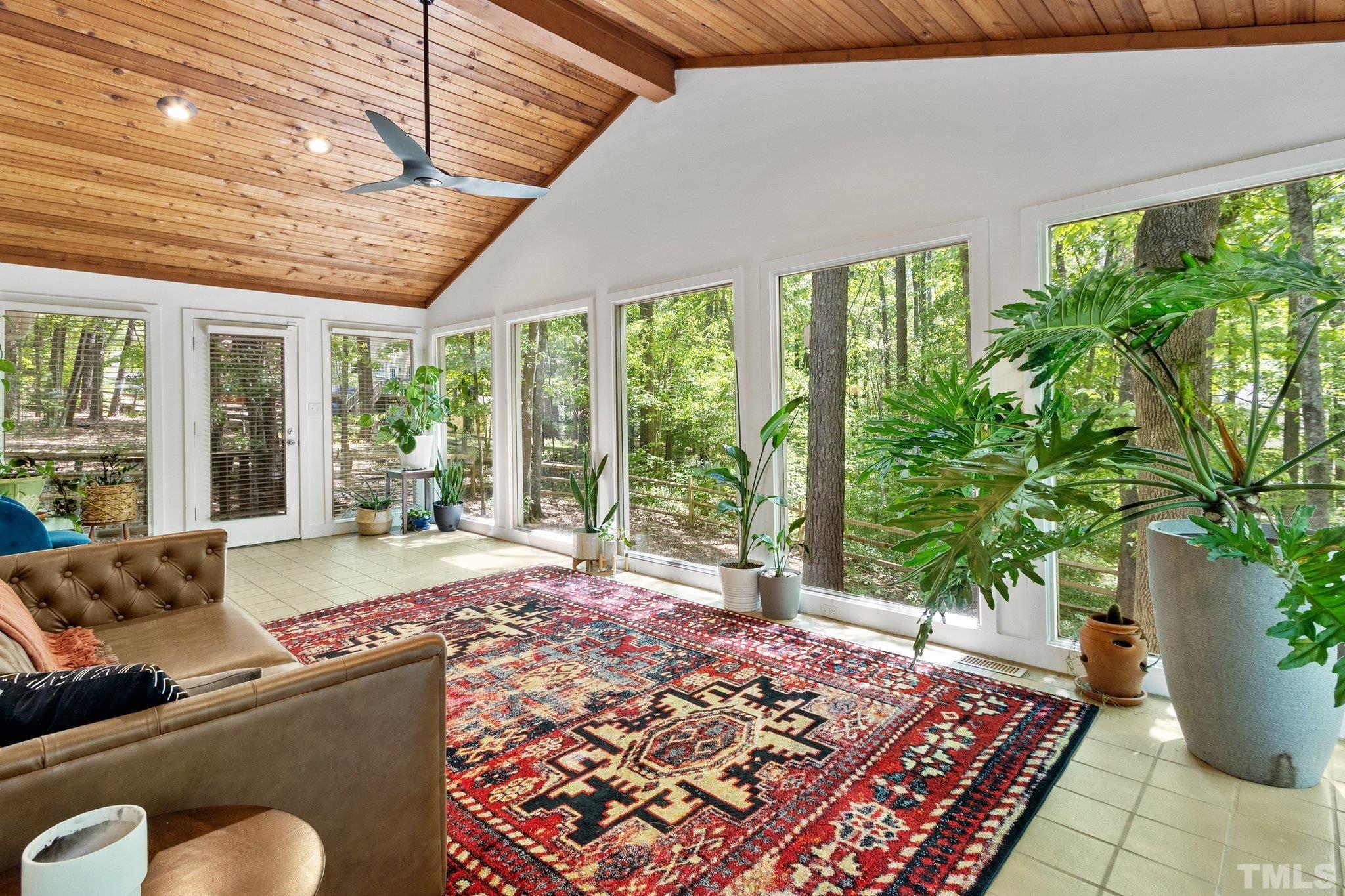 a bed sitting in a spacious bedroom next to a large window