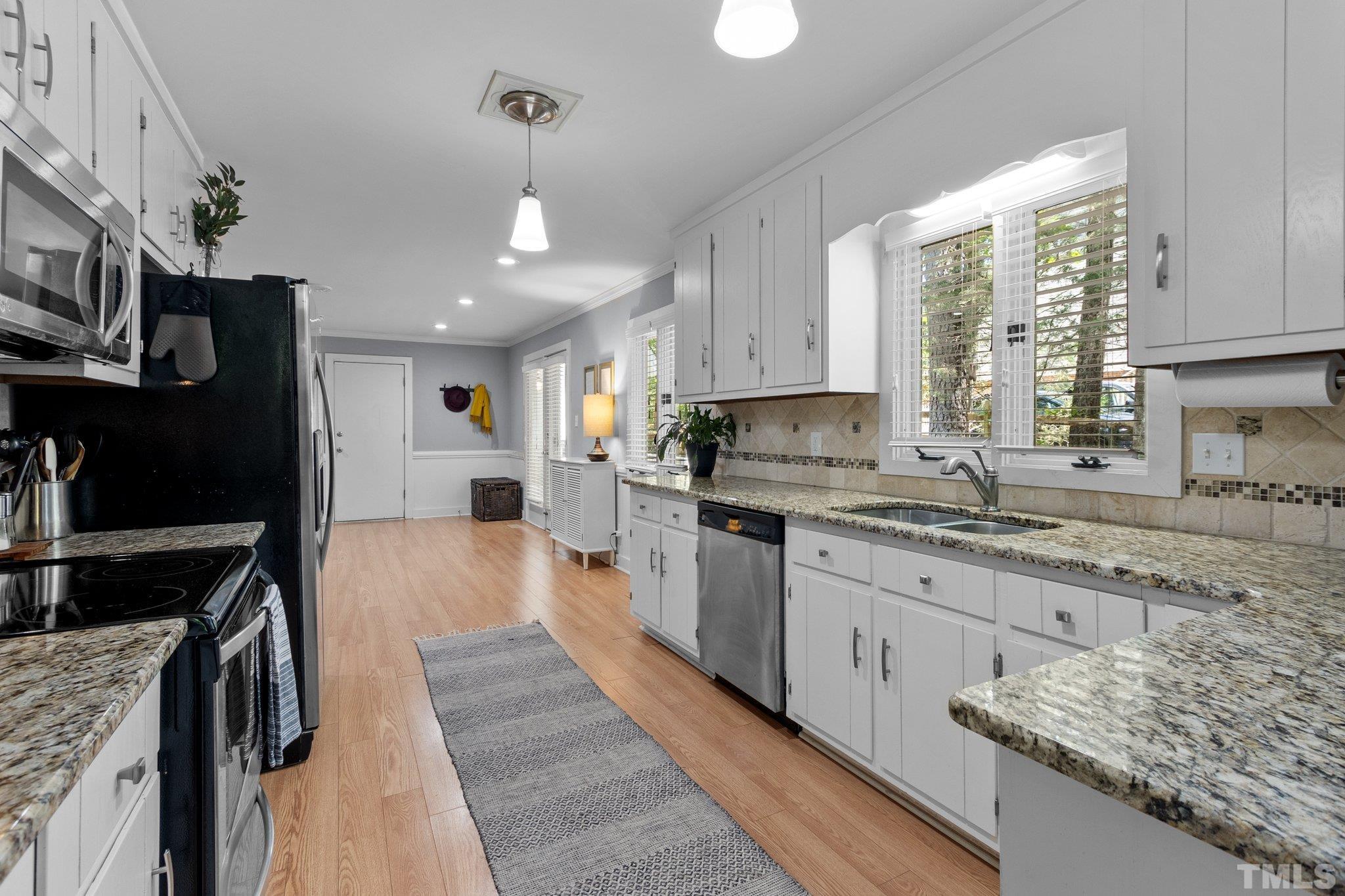 5 St James Court Durham, NC 27713 - Photo 13 of 44 a kitchen with stainless steel appliances granite countertop a stove a sink and a refrigerator