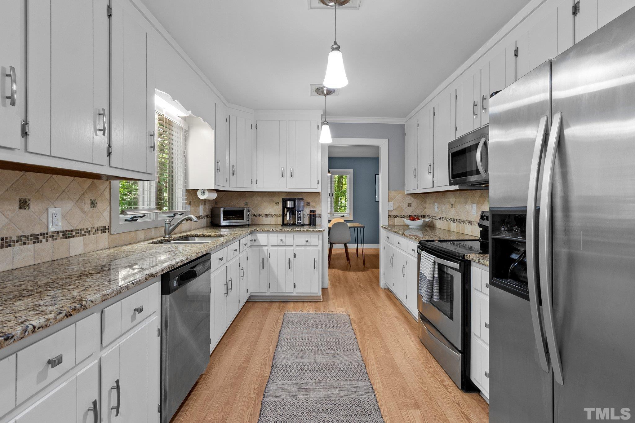 5 St James Court Durham, NC 27713 - Photo 14 of 44 a large kitchen with stainless steel appliances granite countertop a stove a sink and a refrigerator