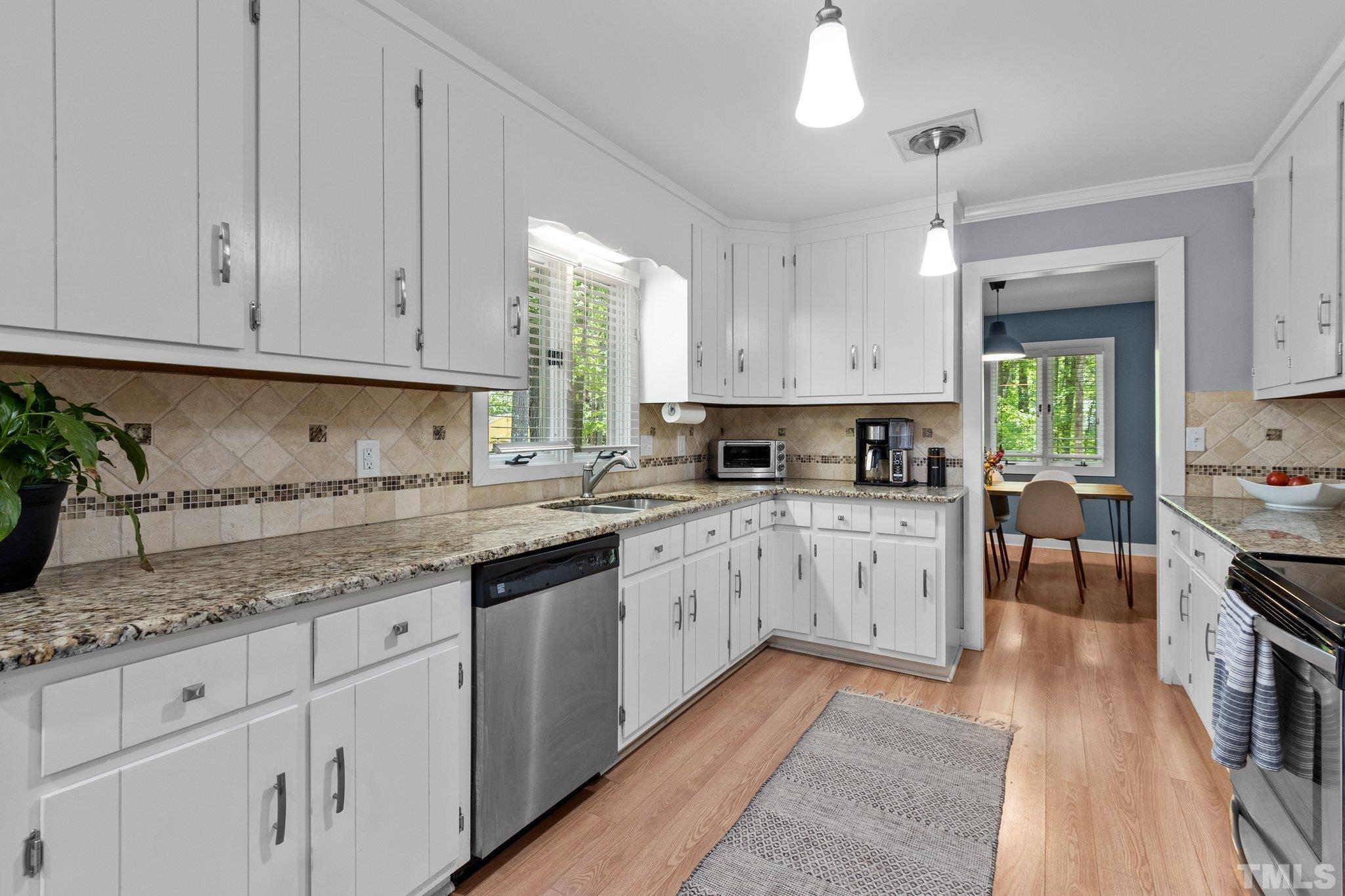 5 St James Court Durham, NC 27713 - Photo 15 of 44 a kitchen with granite countertop white cabinets stainless steel appliances a sink and a stove