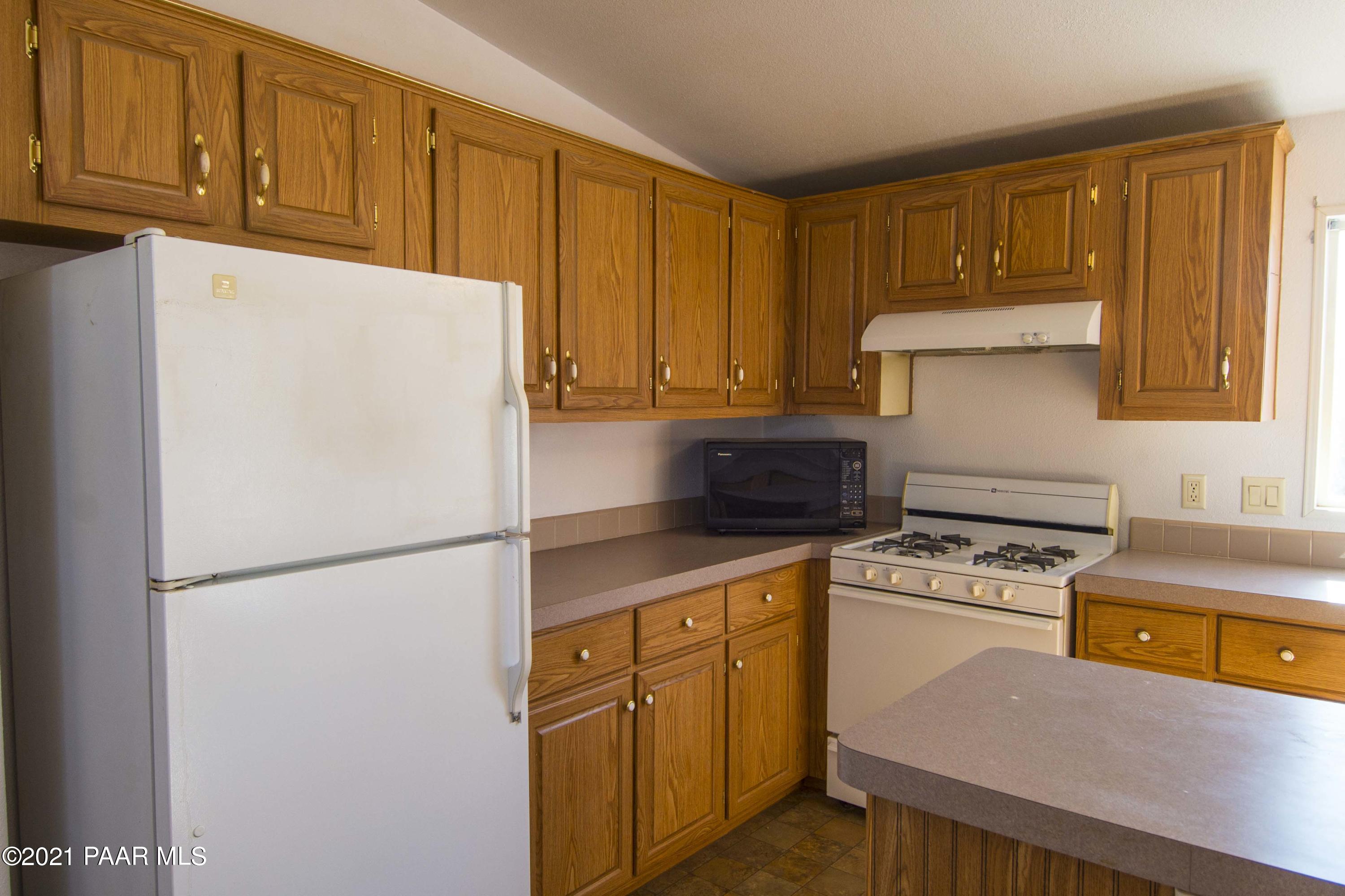 4650 Quail Hollow Road Rimrock, AZ 86335 - Photo 5 of 36 a kitchen with a refrigerator a stove a sink and cabinets