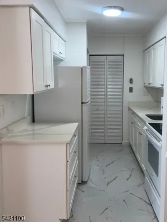 a kitchen with a stove a refrigerator and cabinets