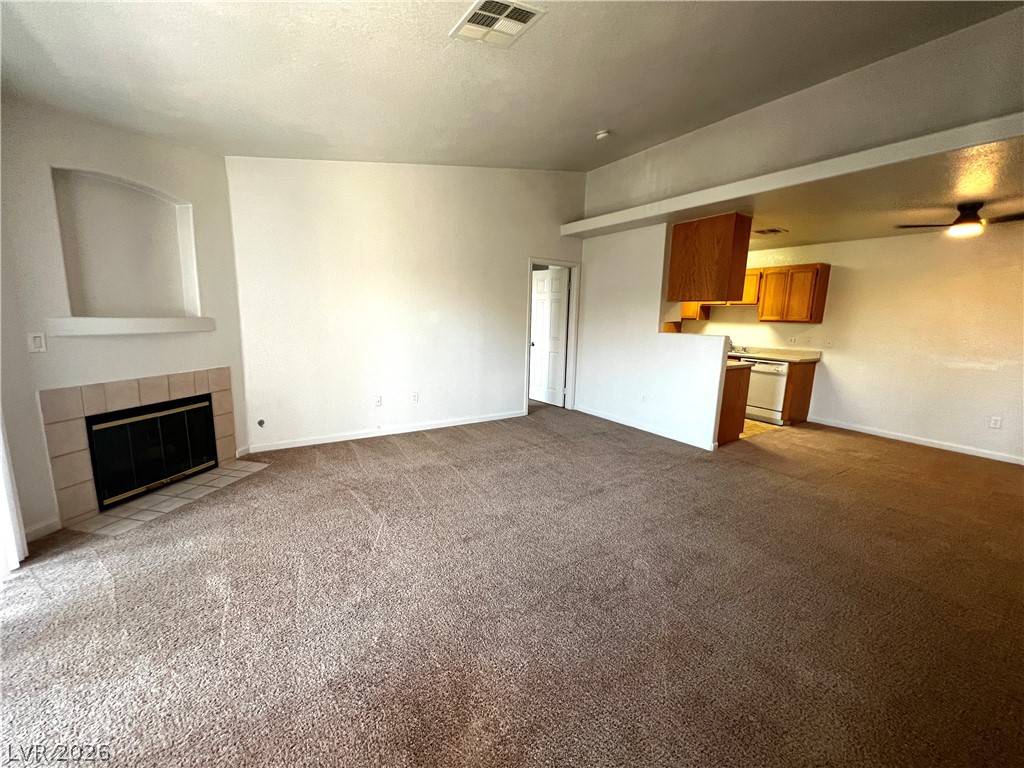 A spacious living area with a cozy fireplace and convenient access to the kitchen.