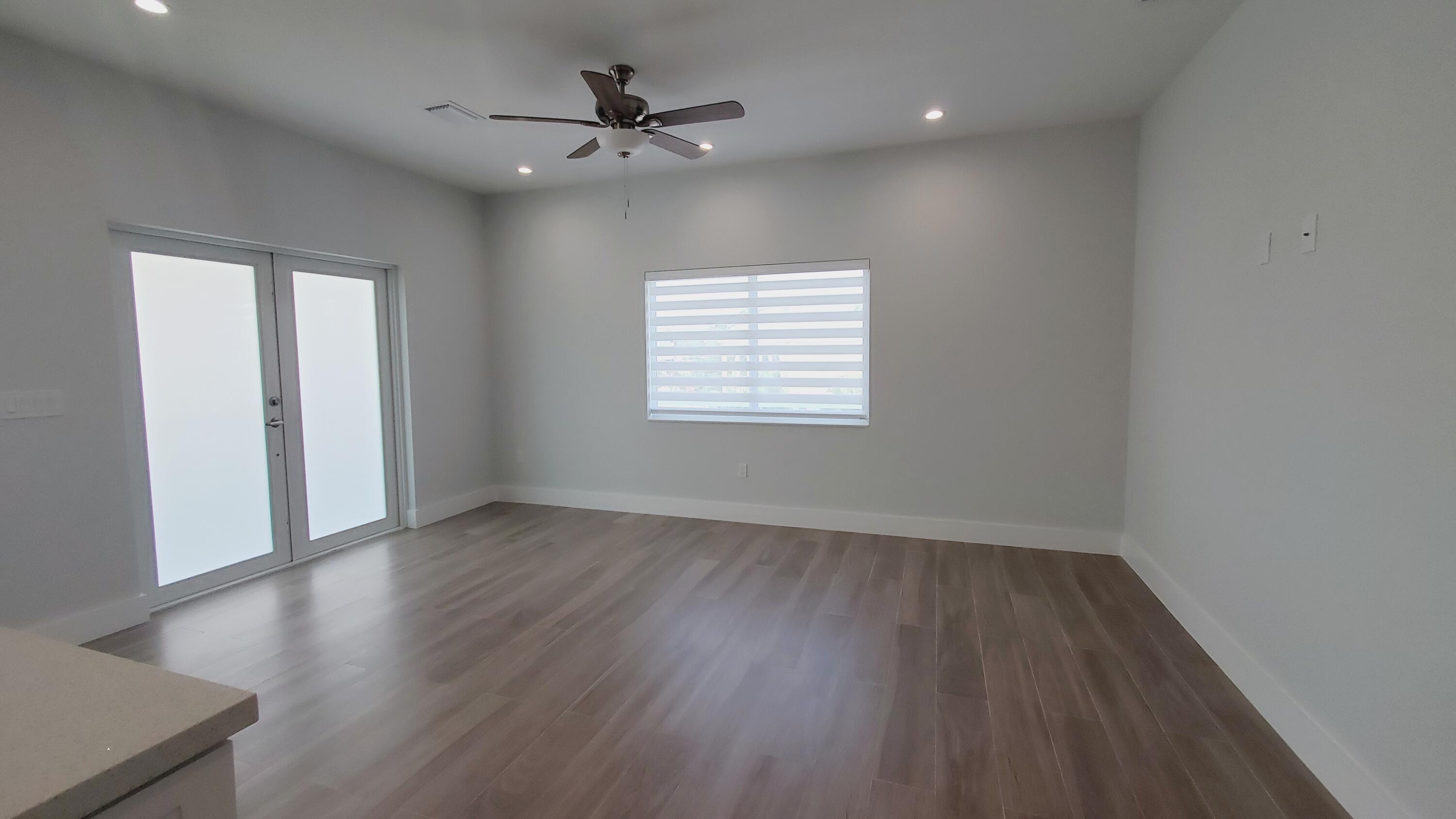 554 Gordon Circle Key Largo, FL 33037 - Photo 12 of 36 an empty room with wooden floor and windows
