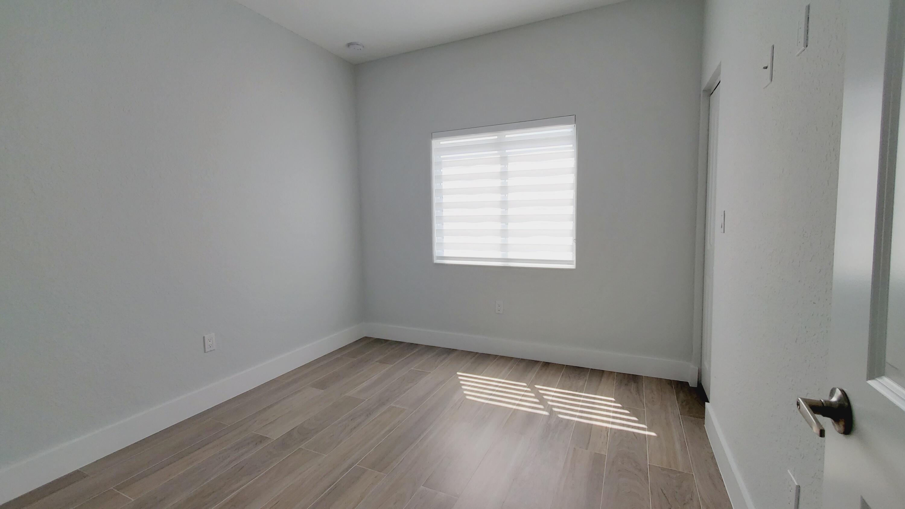 554 Gordon Circle Key Largo, FL 33037 - Photo 25 of 36 an empty room with wooden floor and windows
