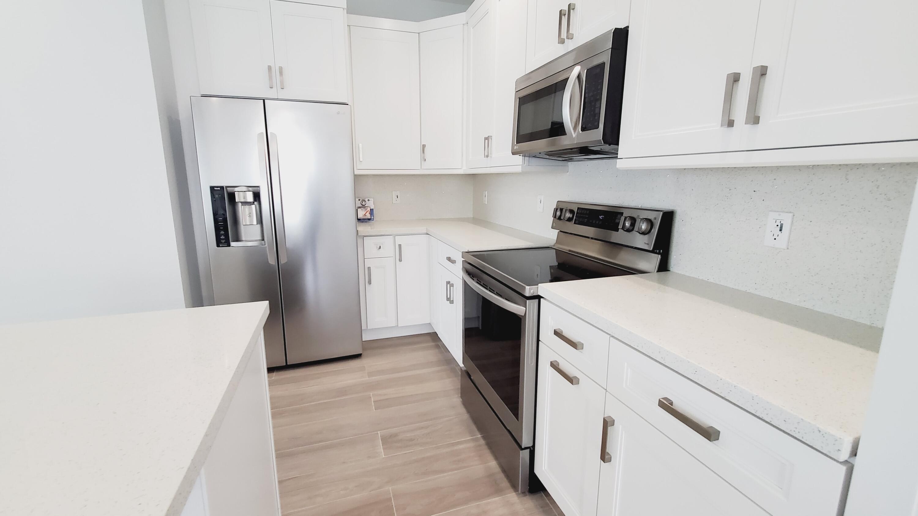554 Gordon Circle Key Largo, FL 33037 - Photo 34 of 36 a kitchen with white cabinets and stainless steel appliances