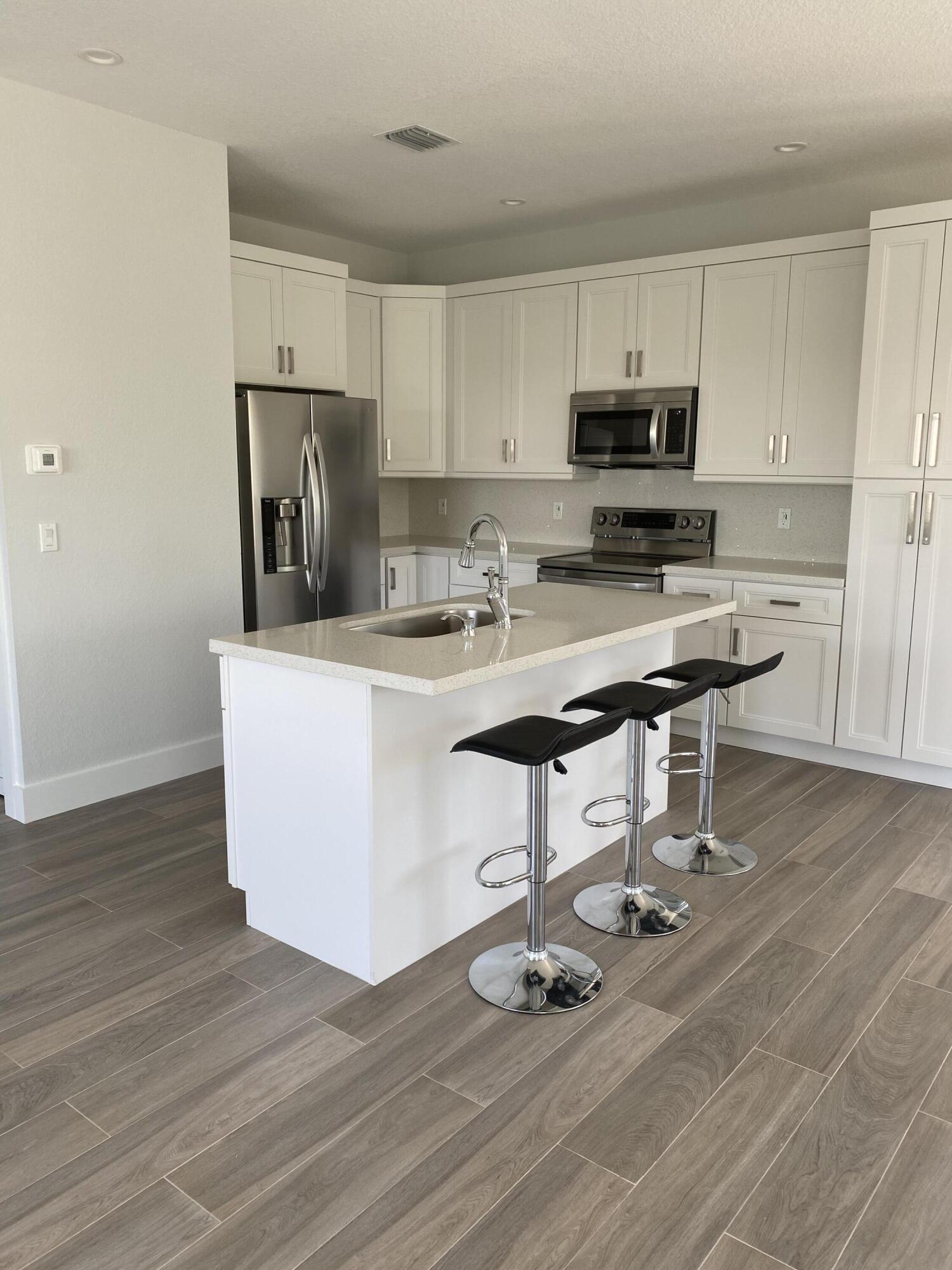 554 Gordon Circle Key Largo, FL 33037 - Photo 10 of 36 a kitchen with kitchen island a white counter top space cabinets and stainless steel appliances