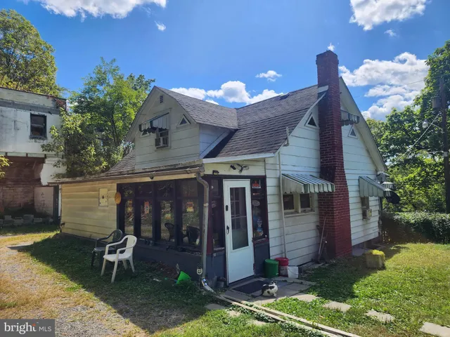 a view of a chair and table in backyard of the house