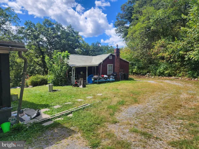 a view of a house with backyard and a tree