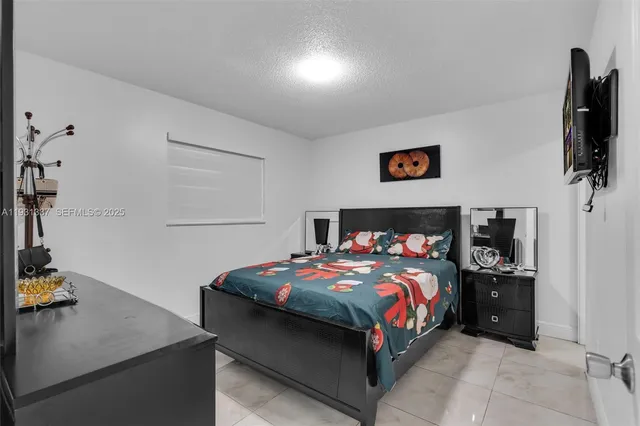 a bedroom with a bed and flat screen tv