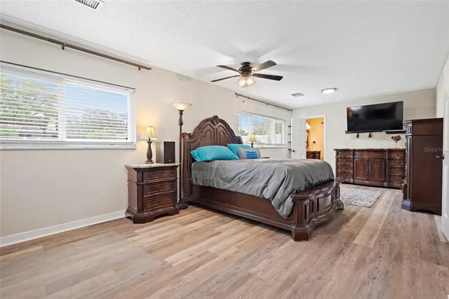 a spacious bedroom with a bed and a flat screen tv