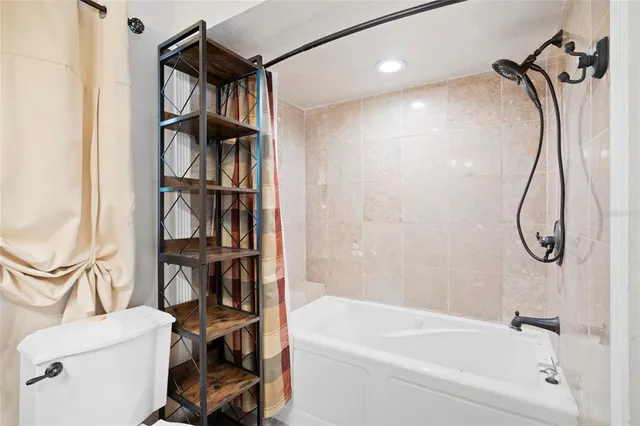 a bathroom with a shower a toilet and a bathtub