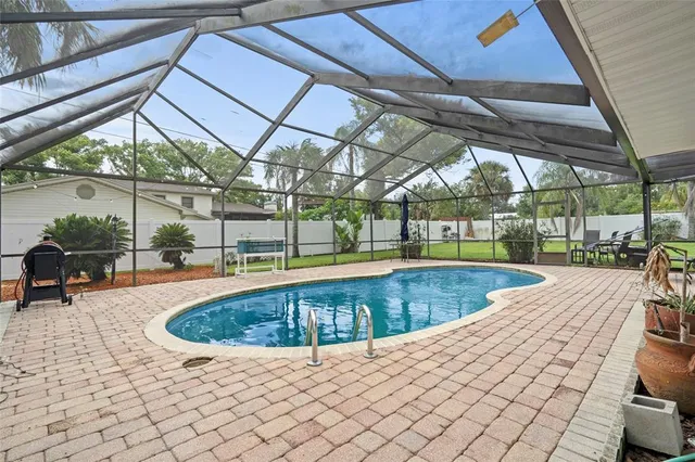 a palm tree sitting in front of a house with a big yard