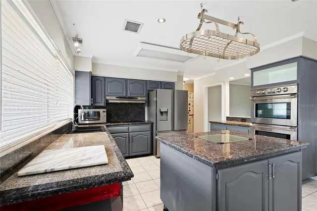 a kitchen with stainless steel appliances granite countertop a sink and stove