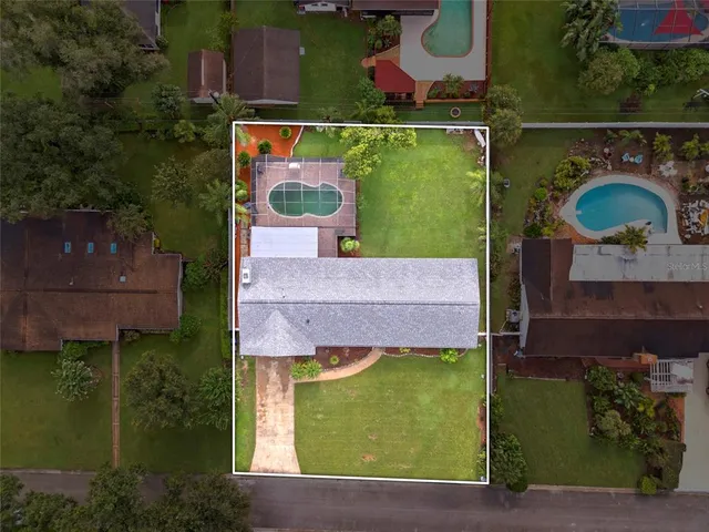 an aerial view of residential houses with outdoor space and trees