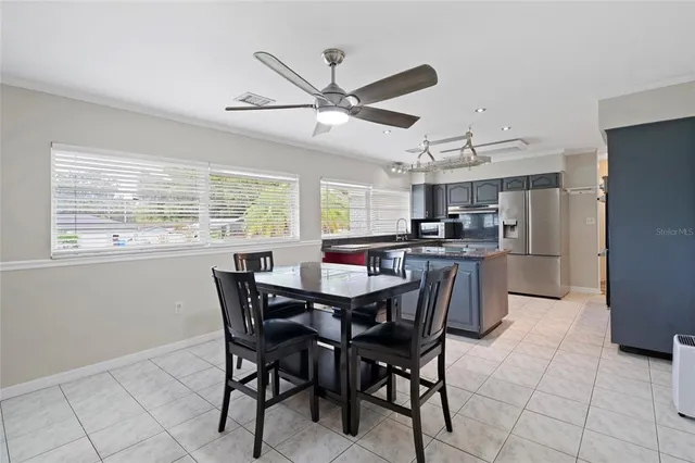 a dining room with stainless steel appliances a table and chairs