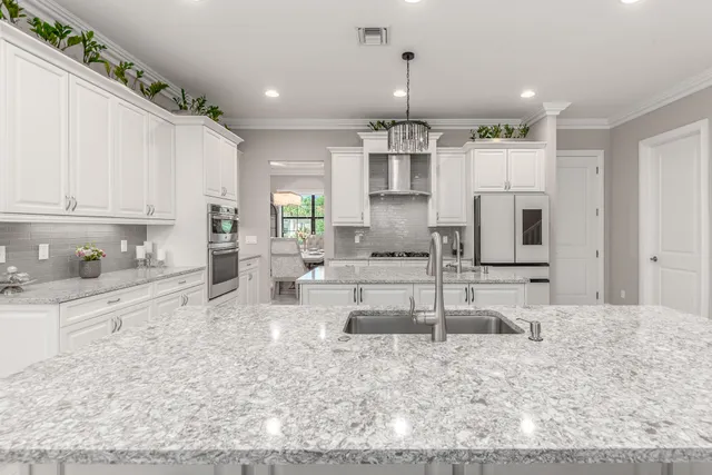 a kitchen with white cabinets and sink