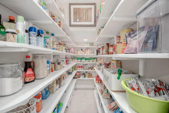 a spacious bedroom with a large bed and a chandelier