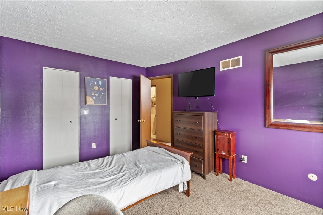 9956 Johnnycake Ridge Road, Unit F4 Painesville, OH 44077 - Photo 21 of 25 Carpeted bedroom with a textured ceiling