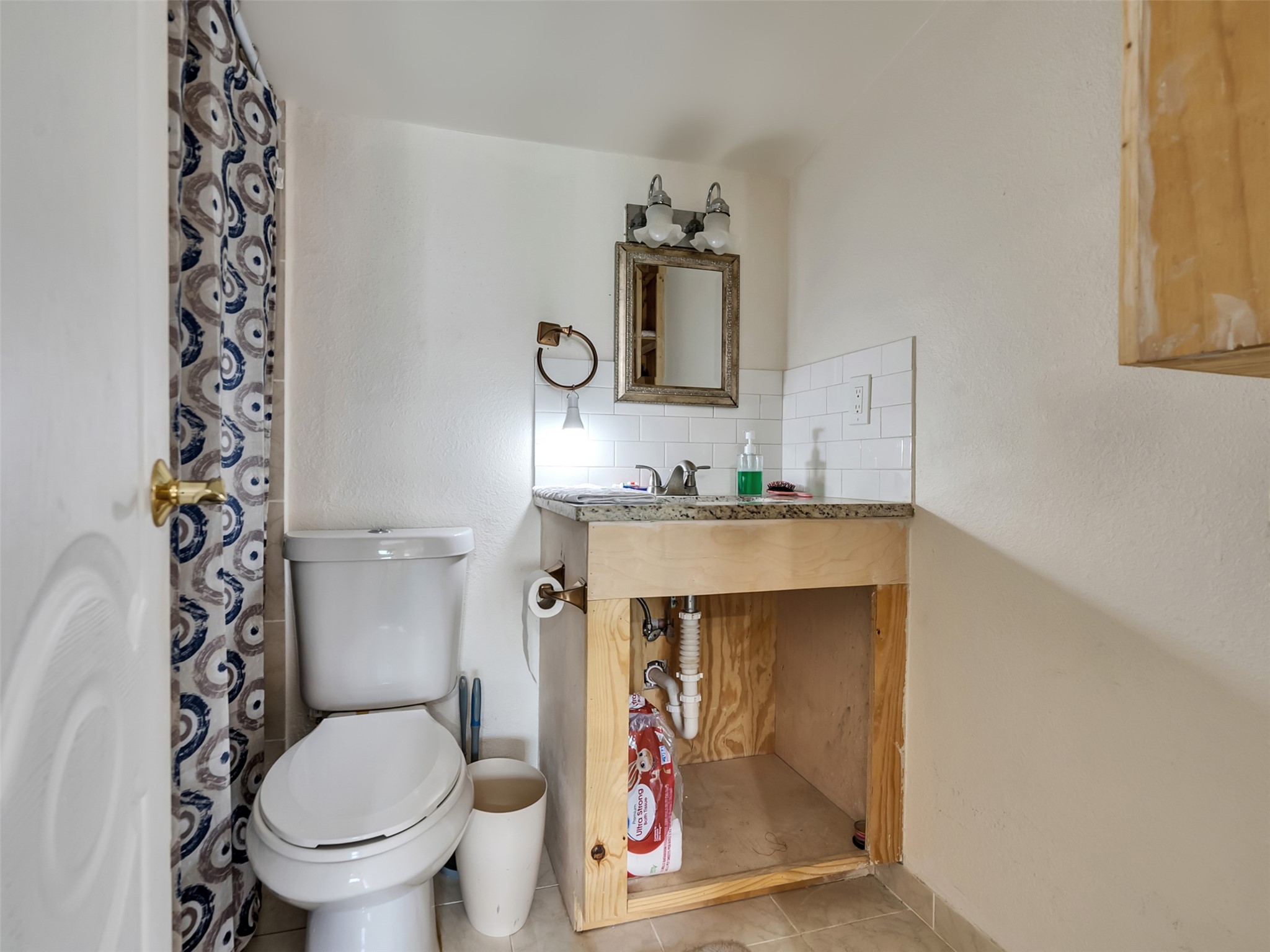 137 County Road 5023 Cleveland, TX 77327 - Photo 27 of 49 a bathroom with a toilet and a shower curtain