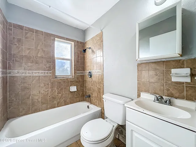 an empty room with a window and ceiling fan