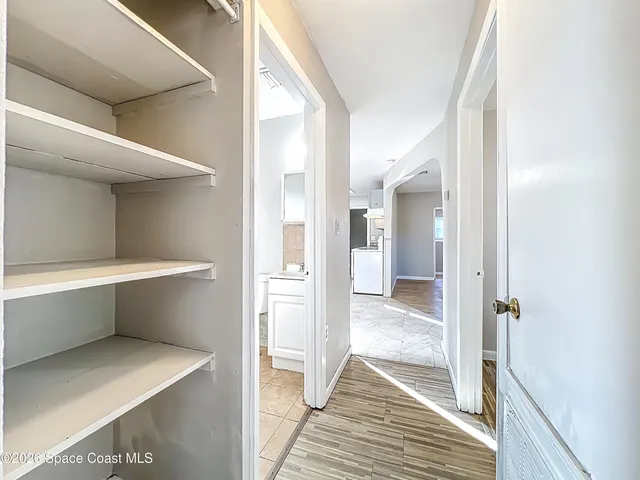 a view of an empty room with wooden floor