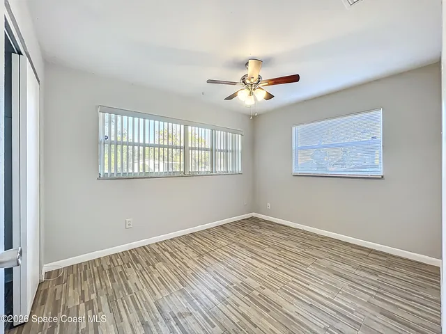 a view of empty room with wooden floor
