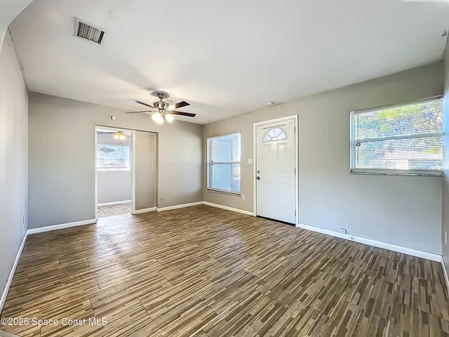 wooden floor in an empty room with a window