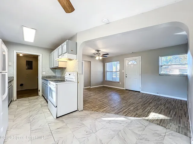 a kitchen that has a sink a window and cabinets