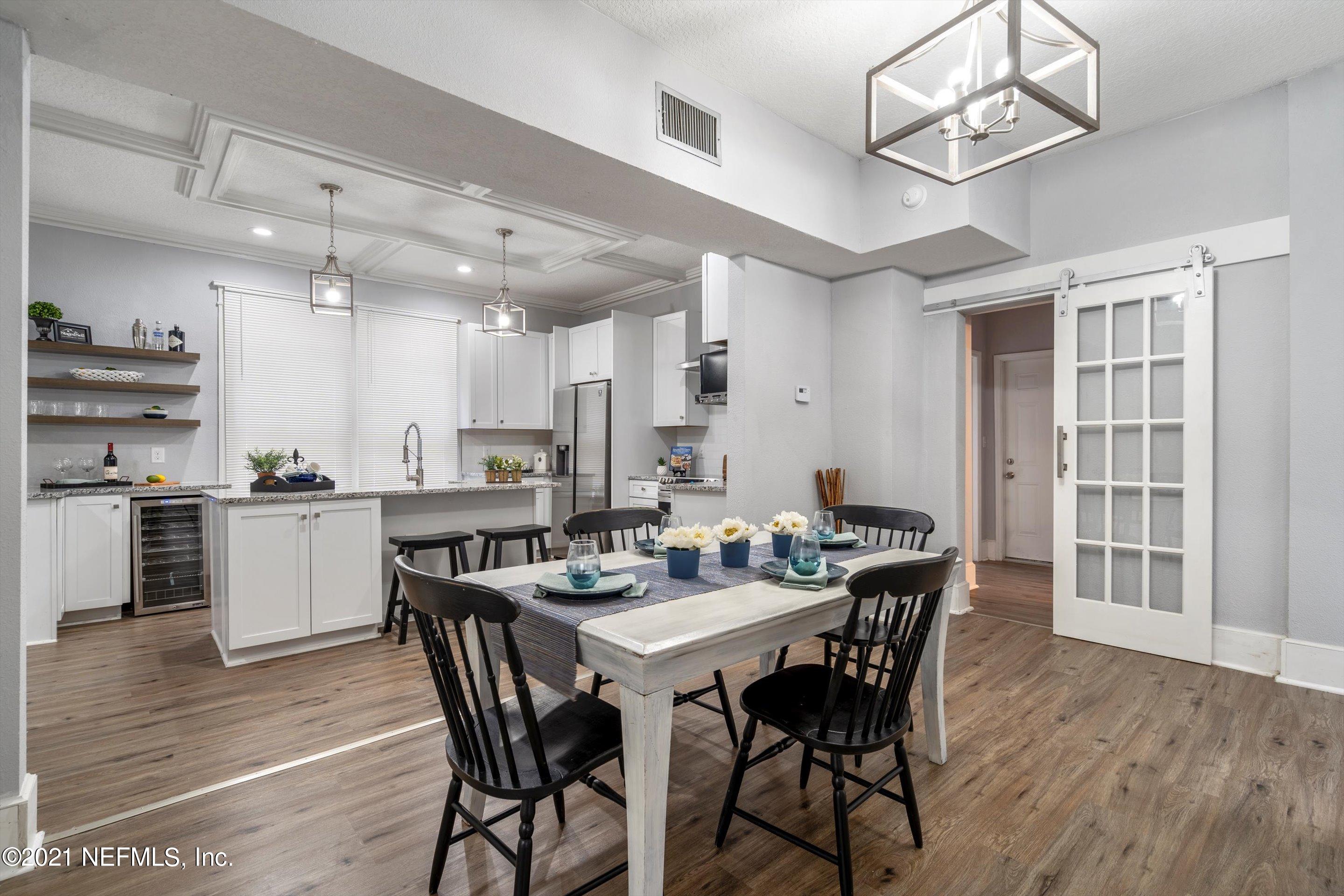 310 West 10th Street Jacksonville, FL 32206 - Photo 16 of 34 a view of a dining room and livingroom with furniture wooden floor a chandelier